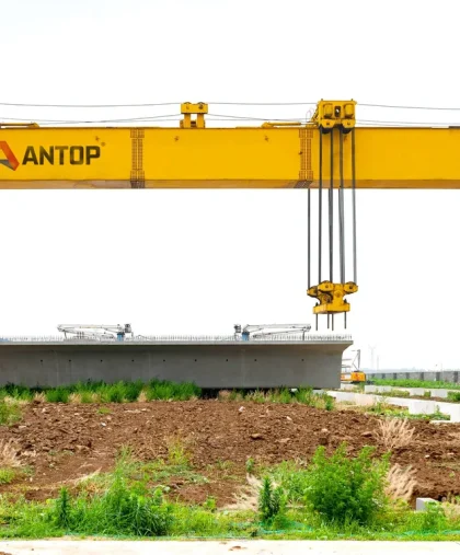 2ca52f48c7e89265232b7e87f239b8d8 rubber tyred gantry crane lifting precast concrete beam in construction yard