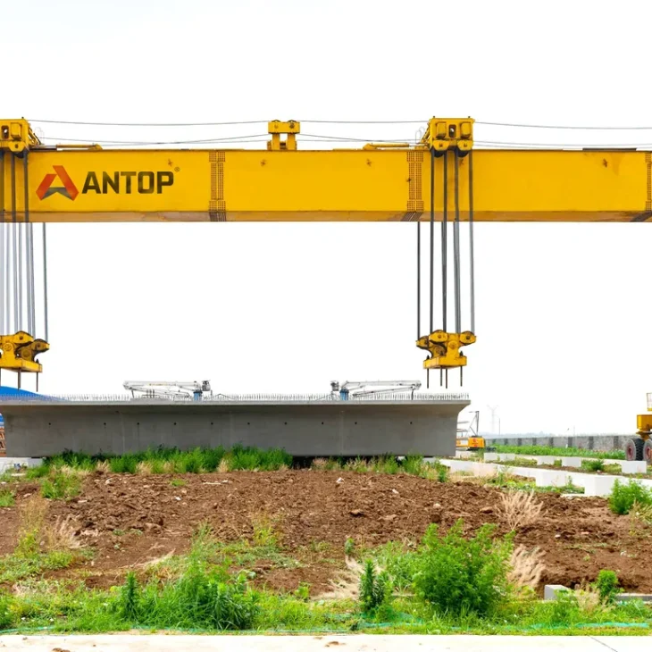 2ca52f48c7e89265232b7e87f239b8d8 rubber tyred gantry crane lifting precast concrete beam in construction yard